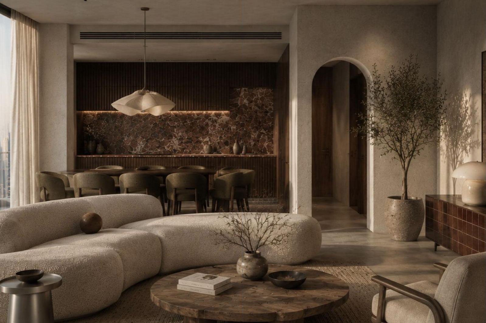 The living area at move-in: curved sofa, dining table under a sculptural pendant, arched doorway