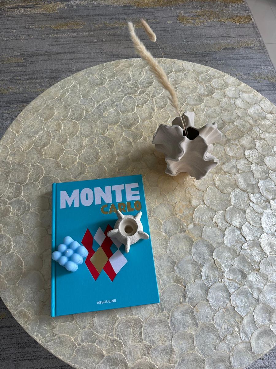 Coffee table styling: a book, a sculptural vase and dried grass on capiz shell