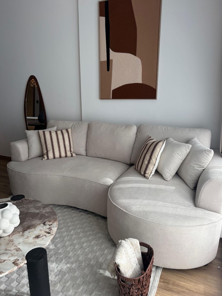 Curved sofa and coffee table, with a woven basket by the arm