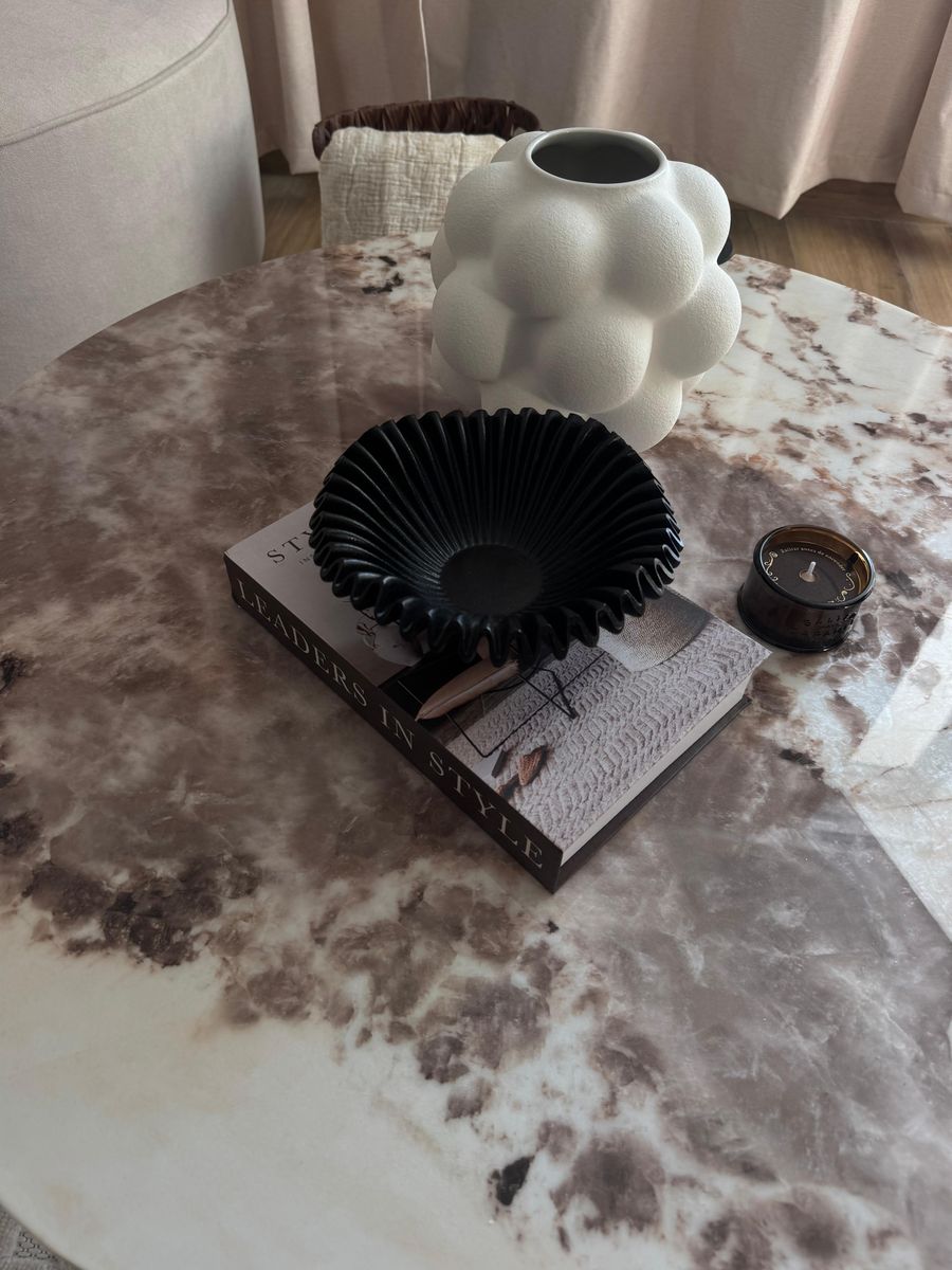 Coffee table from above: cloud vase, black fluted bowl and book