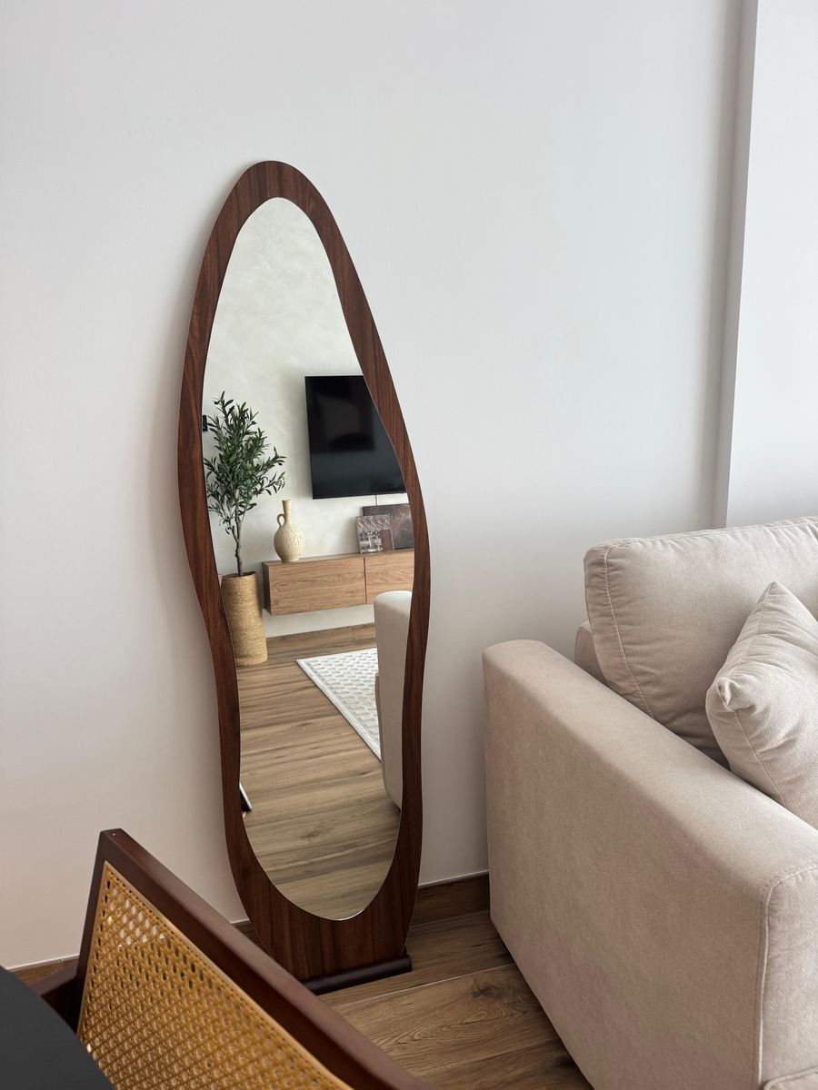 Organic walnut-framed mirror beside the sofa