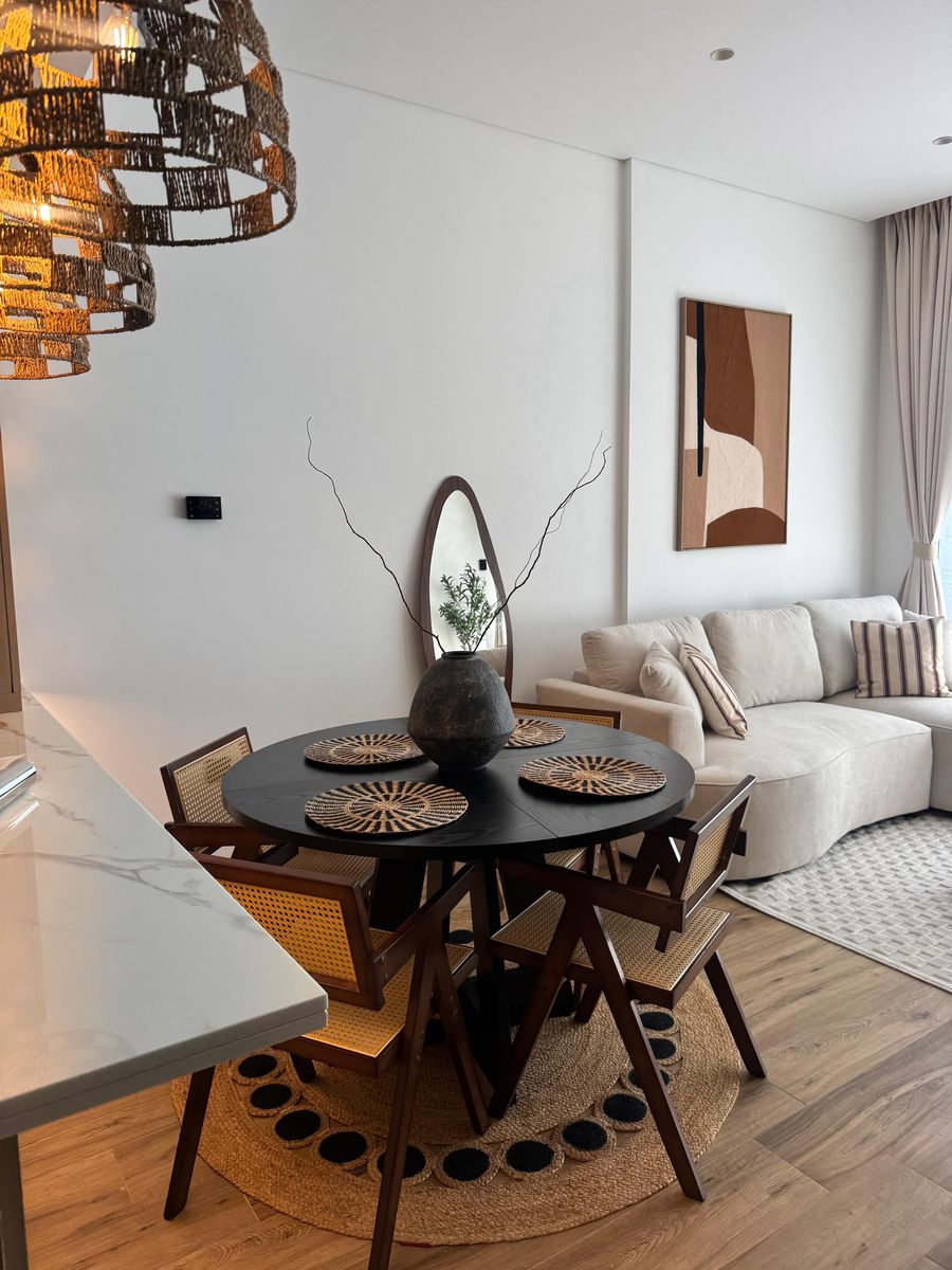 Dining table with woven placemats under woven pendants