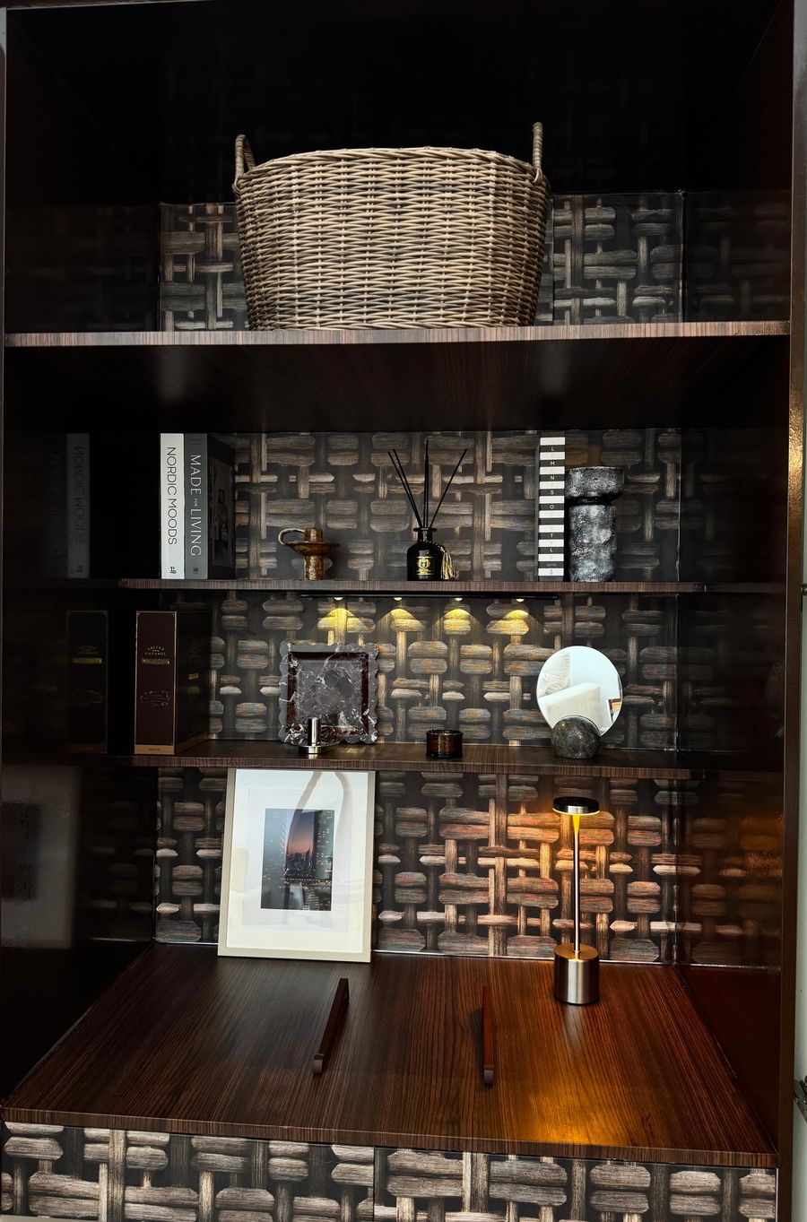 Inside the desk cabinet: books, a diffuser, a framed print and a lamp