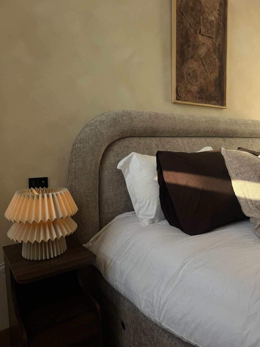 Pleated lamp and cushions on the bed