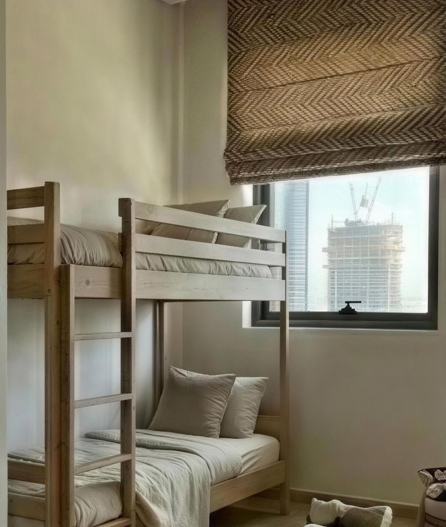 The children's room after: natural wood bunk beds under a herringbone woven blind