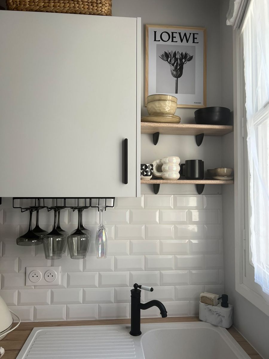 Open oak shelves with ceramics and a glass rack above the sink