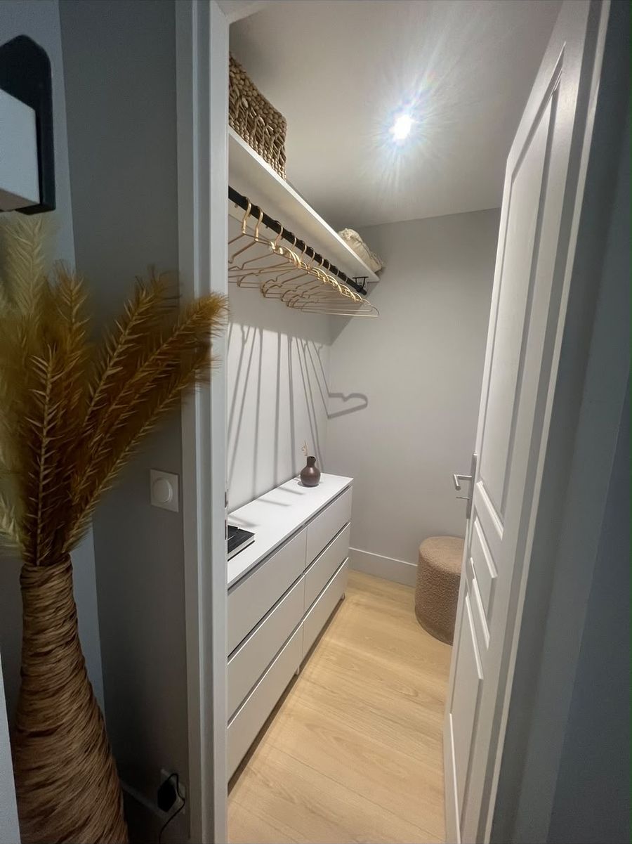 The walk-in closet after: a hanging rail, a shelf and a run of white drawers